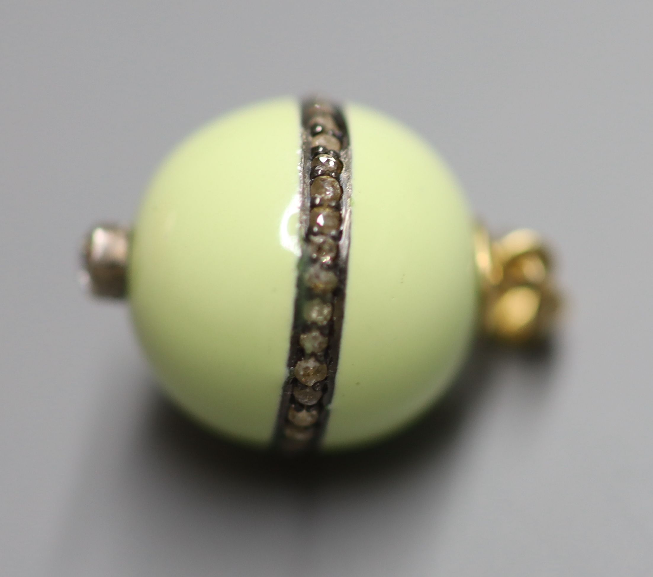 An 18ct, pale green enamel and rose cut diamond set globular pendant, 15mm, gross weight 4.4 grams.